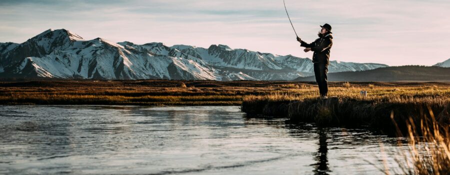 Fisherman casting net into water